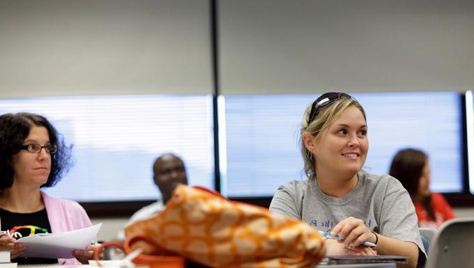A female student smiles in an adult education class.